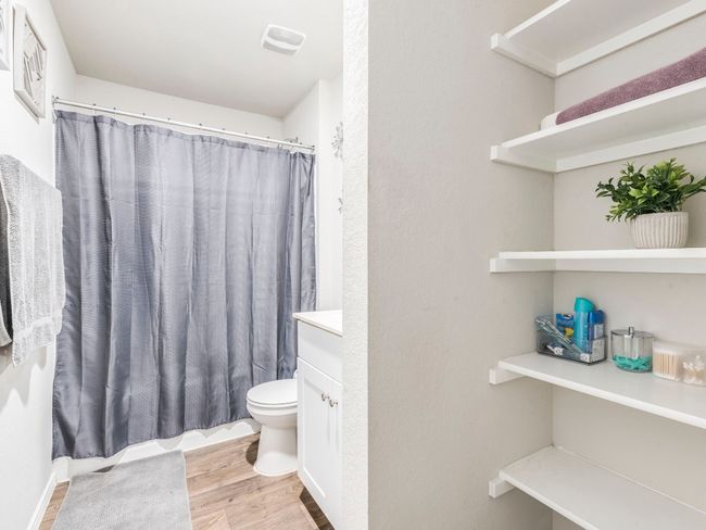 Bathroom with visible vents, wood finished floors, toilet, vanity, and a shower with curtain | Image 25