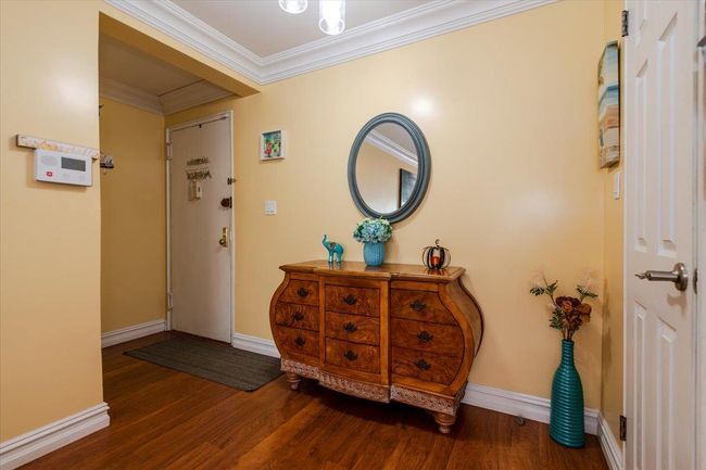 Foyer entrance with wood finished floors and crown molding | Image 4