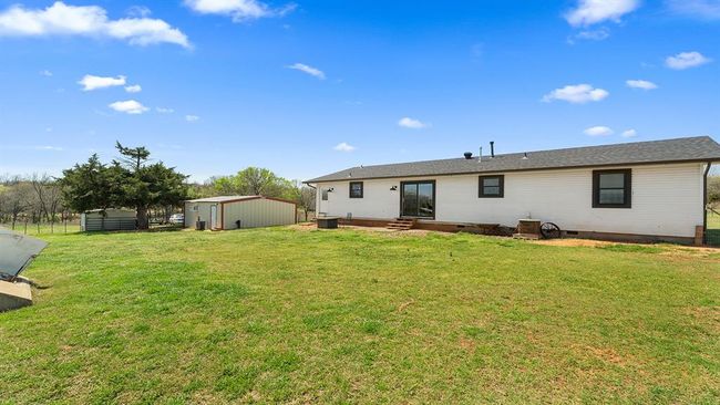 Back of property with an outbuilding, crawl space, a yard, entry steps, and a storage unit | Image 10