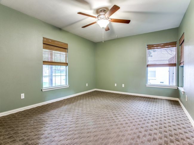 Carpeted spare room featuring baseboards and ceiling fan | Image 13