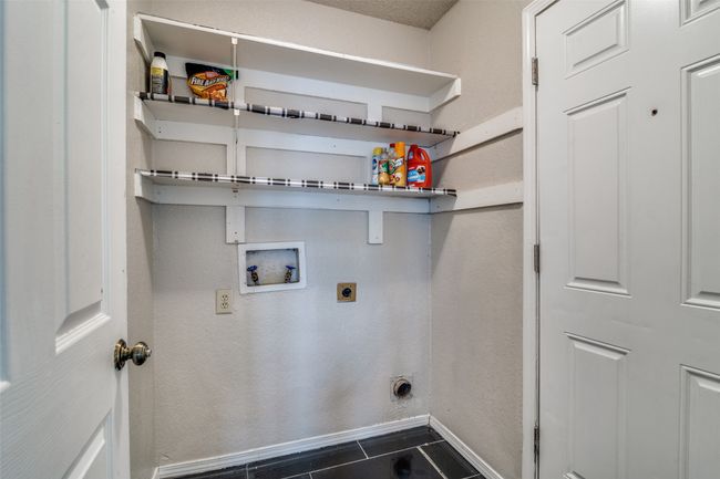 Laundry area with electric dryer hookup, washer hookup, and dark tile patterned floors | Image 12