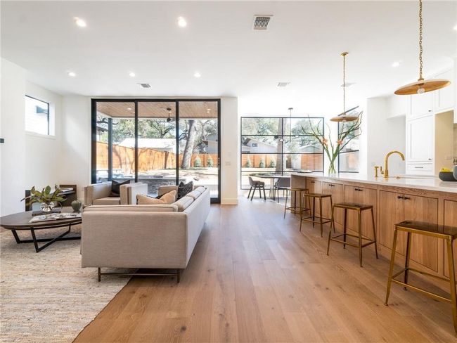 Living area with light wood-type flooring, floor to ceiling windows, and recessed lighting | Image 5