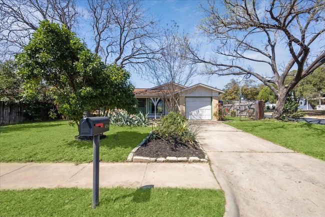 View of front facade with a garage, concrete driveway, a front yard, and fence | Image 30