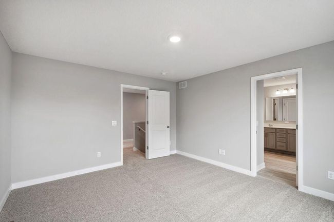 Primary bedroom with walk-in closet and private bath. Model home. Options and colors will vary. | Image 22