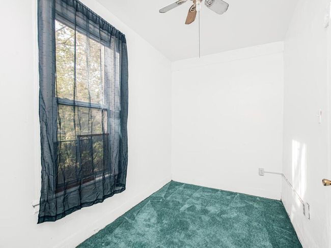 Carpeted empty room featuring a ceiling fan | Image 16