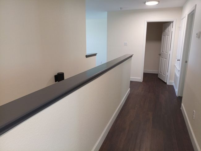 Corridor with dark wood-style floors and an upstairs landing | Image 19