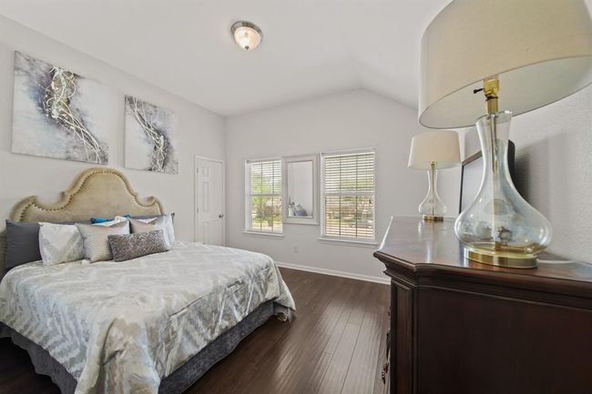 This is another generously sized bedroom featuring elevated ceilings, a generous walk-in closet, and bright windows overlooking the front yard. | Image 40