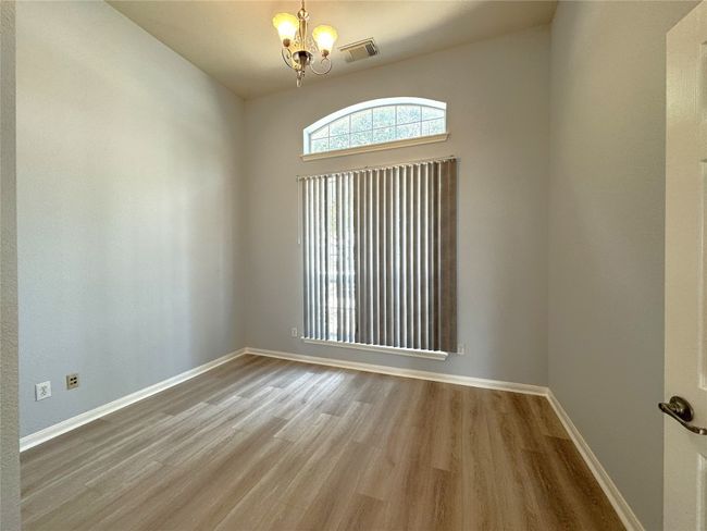 Empty room featuring a chandelier and wood finished floors | Image 4