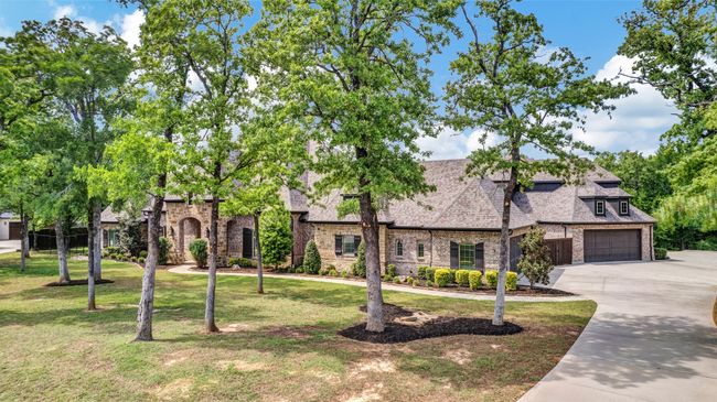The 3 garages holding 5 cars all have additional built-in cabinets, decked storage attics and epoxy floors. | Image 39