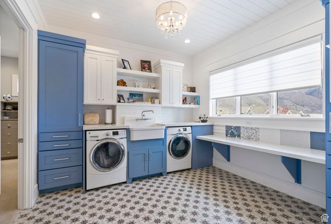 Clothes washing area featuring a sink, a chandelier, recessed lighting, cabinet space, and light floors | Image 17