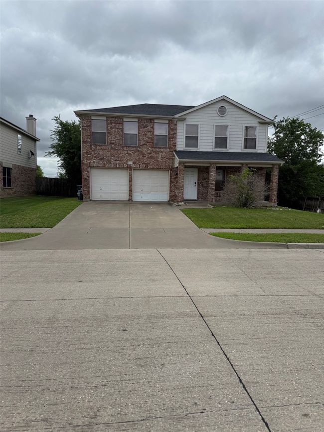 View of front facade with a garage, driveway, and brick siding | Image 26