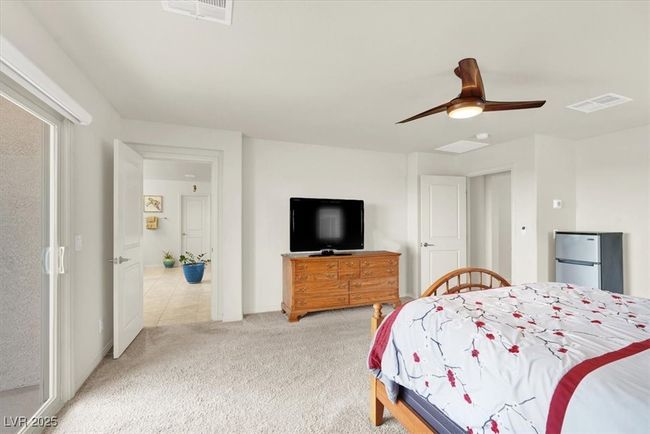 Bedroom with light carpet, ceiling fan, and freestanding refrigerator | Image 33