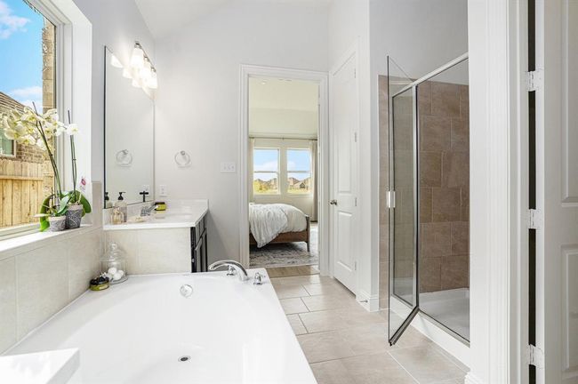 The view from the primary bath shows one of the two sinks, the soaking tub and separate shower | Image 15