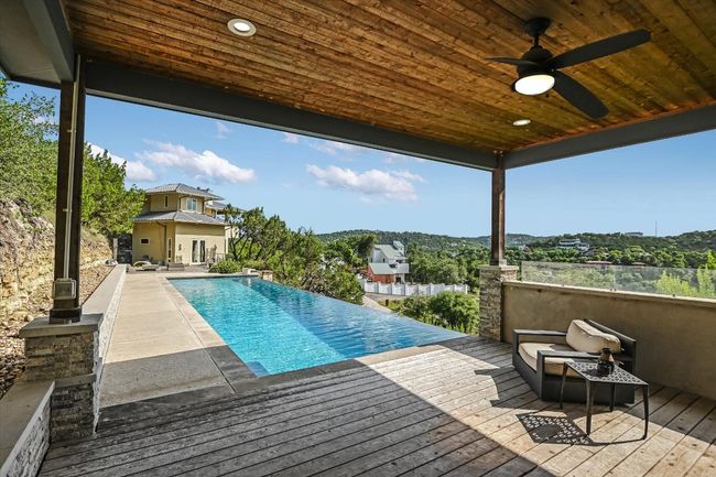 View of swimming pool with a deck, ceiling fan, and an infinity pool | Image 38