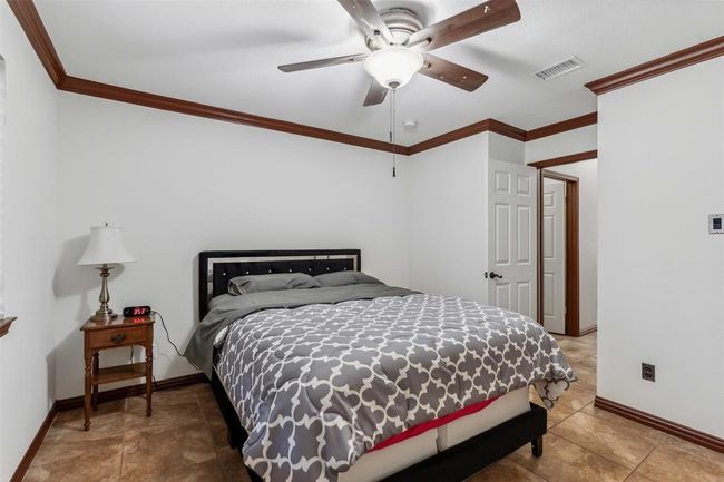 Bedroom with visible vents, ceiling fan, crown molding, and baseboards | Image 7