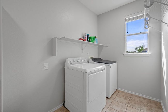 Laundry room featuring washer and dryer, baseboards, and light tile patterned floors | Image 27
