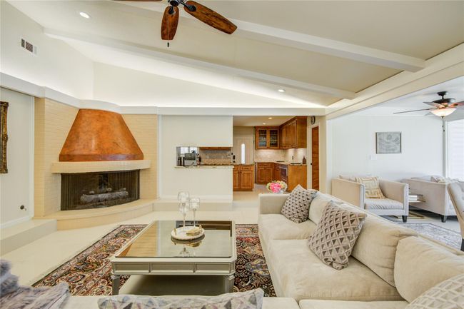 The bright family room features acozy corner fireplace, vaultedceiling with ambient surroundand recessed lighting, and isopen to the dining room andkitchen. | Image 8
