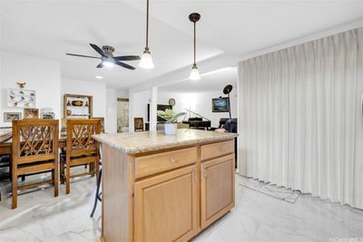 A kitchen island provides additional storage and seating options. | Image 3