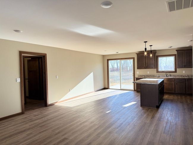 The center island boasts a breakfast bar along dining room side. | Image 5