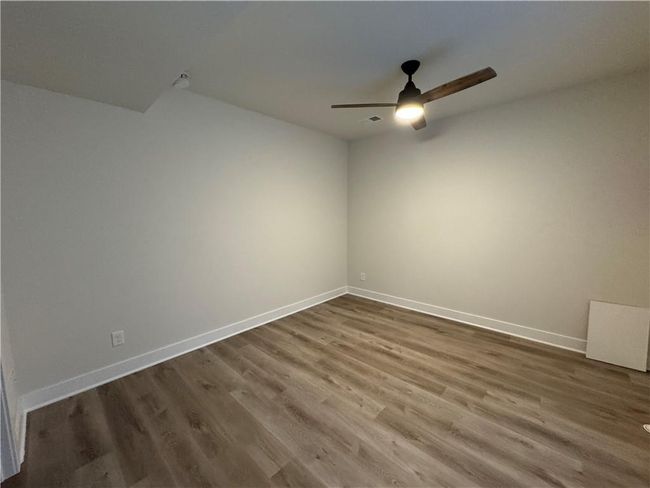 Spare room with a ceiling fan and wood finished floors | Image 62