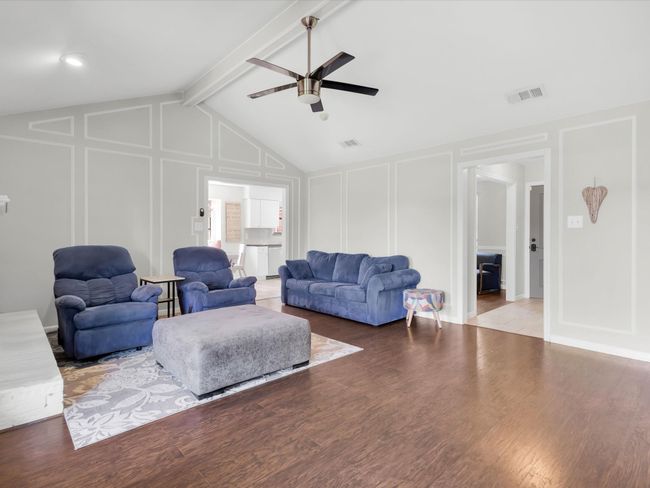 Living room with a decorative wall, ceiling fan, and wood finished floors | Image 13
