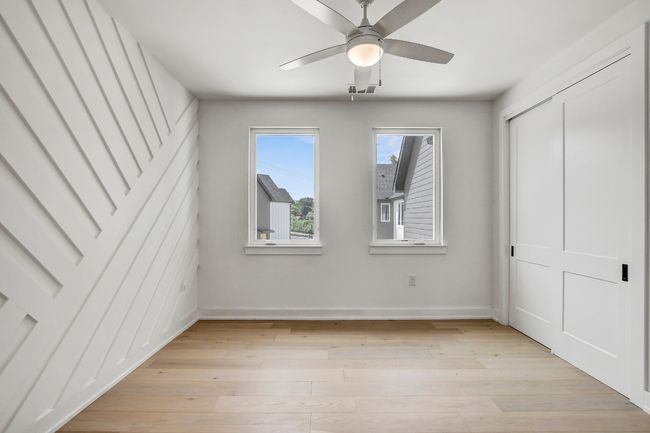 Unfurnished bedroom featuring light wood-type flooring, baseboards, a ceiling fan, and a closet | Image 17