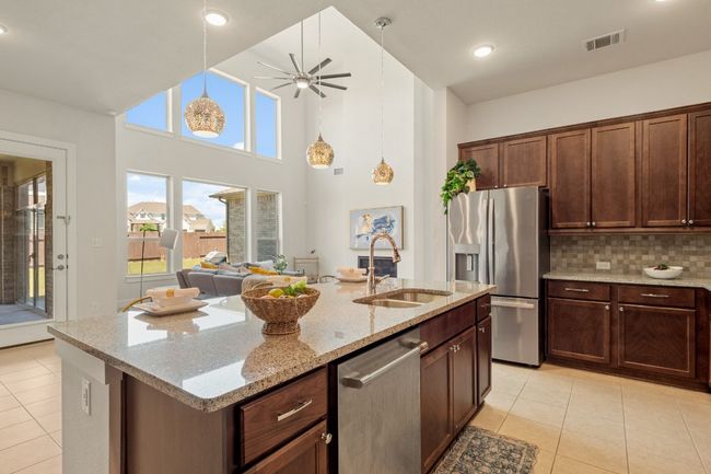 Kitchen featuring stainless steel appliances, a sink, visible vents, and light tile patterned floors | Image 9