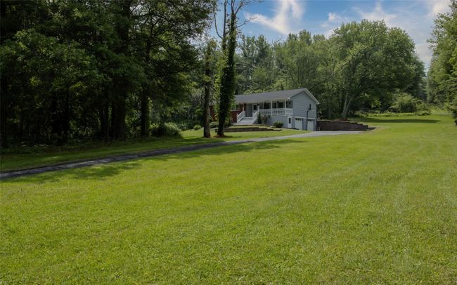 View of grassy yard with an attached garage and driveway | Image 11