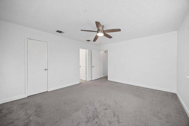 Unfurnished bedroom with baseboards, carpet flooring, a textured ceiling, and visible vents | Image 17