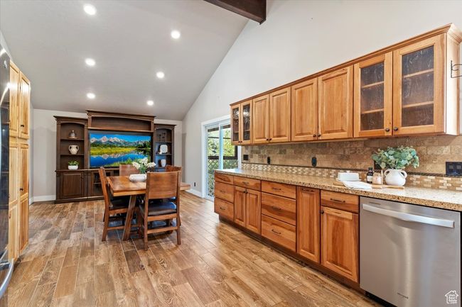 Kitchen featuring dishwasher, light stone counters, decorative backsplash, light wood-style flooring, and recessed lighting | Image 11