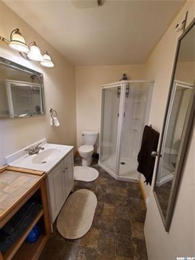 Bathroom featuring toilet, vanity, tile patterned flooring, and an enclosed shower | Image 27
