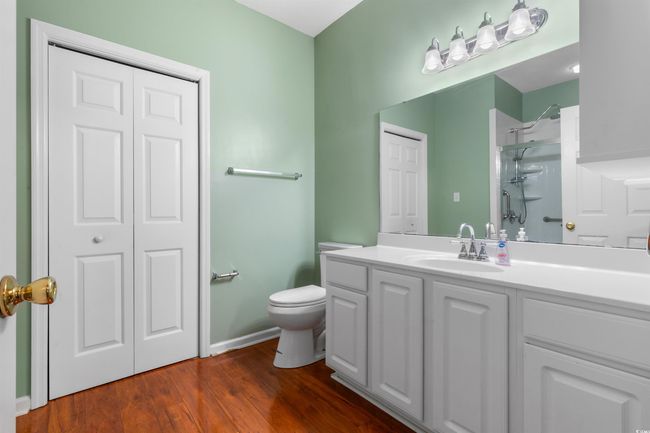 Bathroom with toilet, a shower, vanity, wood finished floors, and baseboards | Image 25