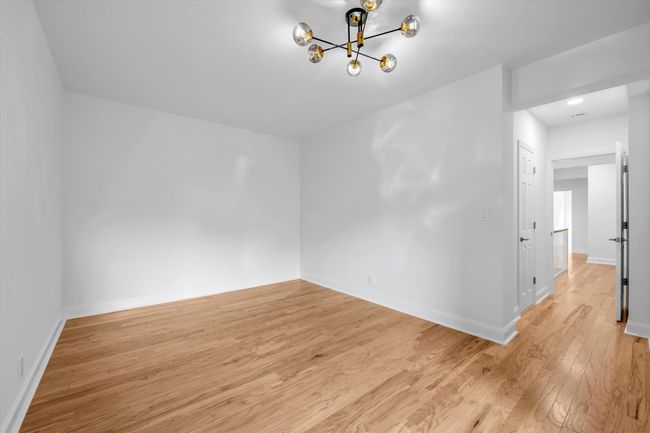Unfurnished room featuring light wood finished floors and a chandelier | Image 13
