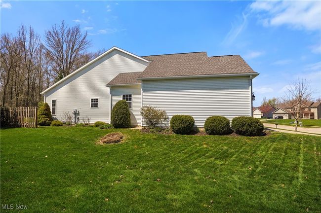 View of home's exterior featuring roof with shingles and a yard | Image 44