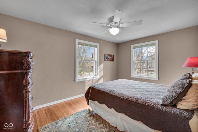 bedroom with baseboards, ceiling fan, wood finished floors, and multiple windows | Image 24