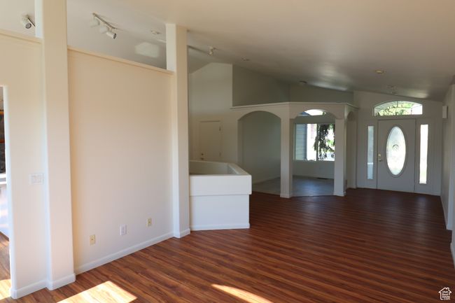 Foyer featuring vaulted ceiling, wood finished floors, and arched walkways | Image 6