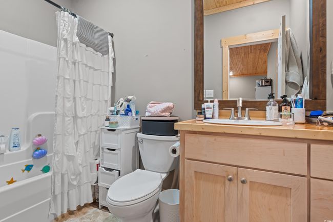 Bathroom featuring vanity and shower / bathtub combination with curtain | Image 35