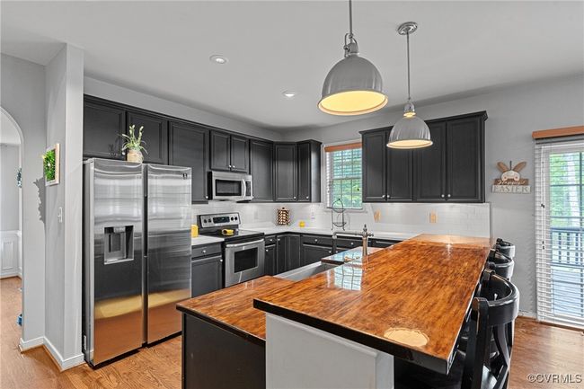 Kitchen featuring appliances with stainless steel finishes, decorative backsplash, and plenty of natural light | Image 12