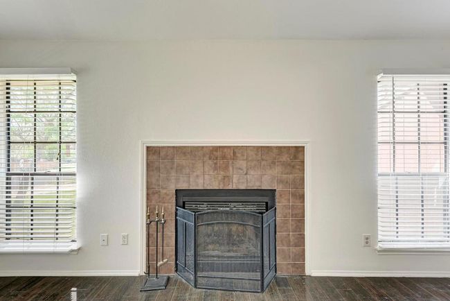 Details featuring baseboards, wood finished floors, and a tiled fireplace | Image 10