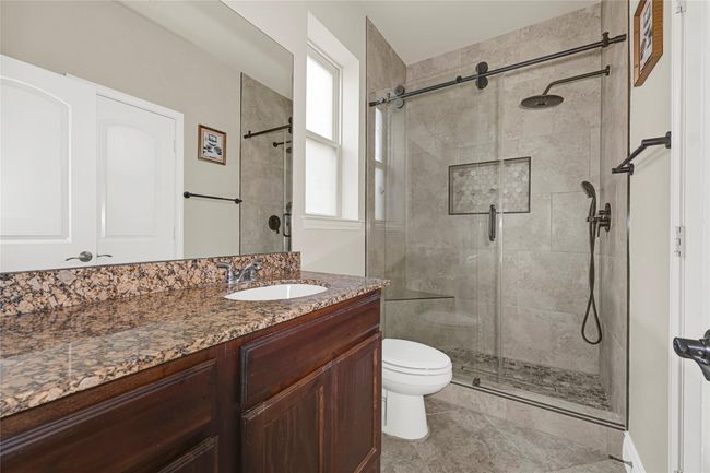 The en suite bath offers an enclosed shower, a wide vanity, and modern finishes that make this guest suite a standout. | Image 20