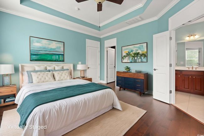Bedroom featuring a sink, visible vents, a raised ceiling, dark wood-style floors, and ornamental molding | Image 20