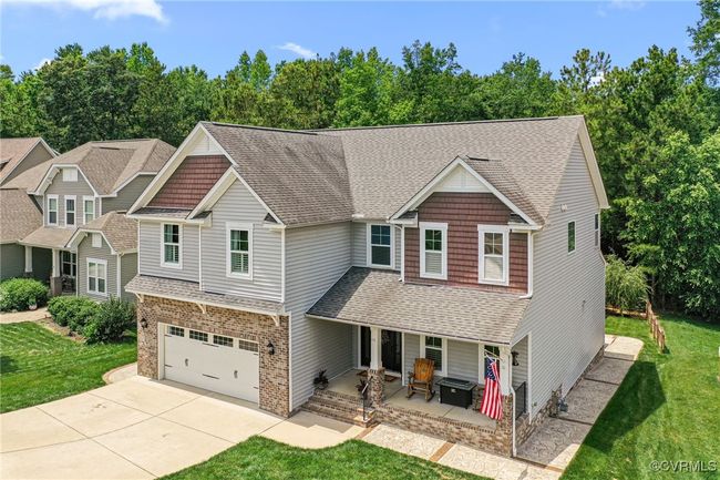 Craftsman-style house with an attached garage, a shingled roof, concrete driveway, and a front lawn | Image 39