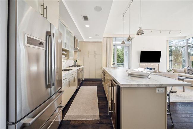 The recently replaced porcelain countertops, refrigerator, dishwasher, wine cooler, sink and faucet show off this beautiful, like new kitchen. | Image 9