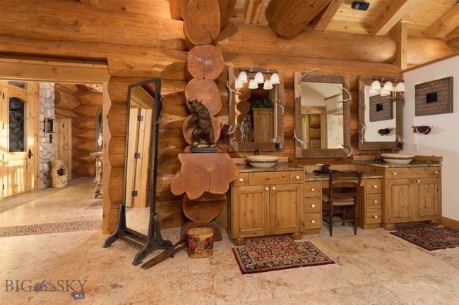 Primary bathroom featuring log walls and cathedral beam ceiling. | Image 22
