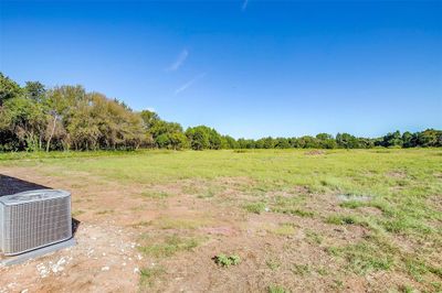 View of yard featuring central AC unit and a rural view | Image 1