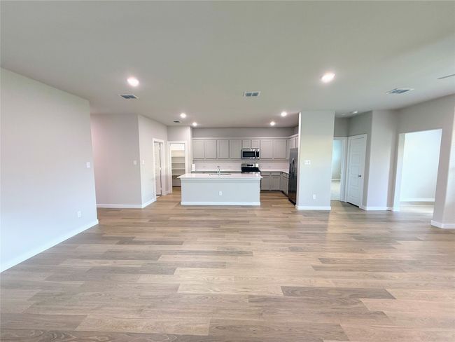 Kitchen with stainless steel appliances, open floor plan, recessed lighting, baseboards, and light wood-type flooring | Image 8