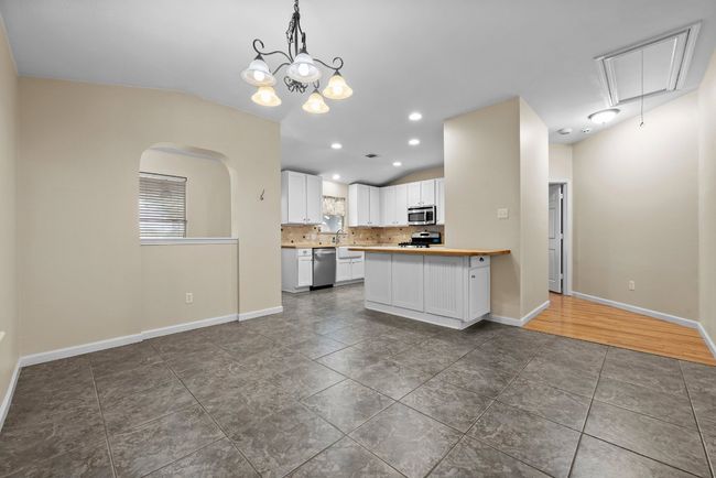 Kitchen featuring stainless steel appliances white cabinetry, decorative backsplash | Image 21