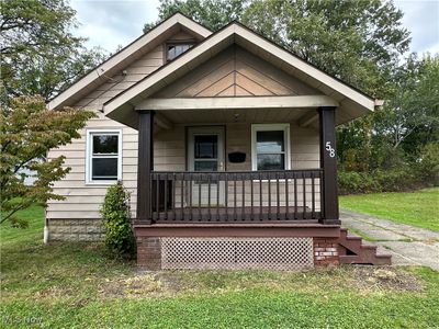 Bungalow-style house featuring a porch and a front lawn | Image 1