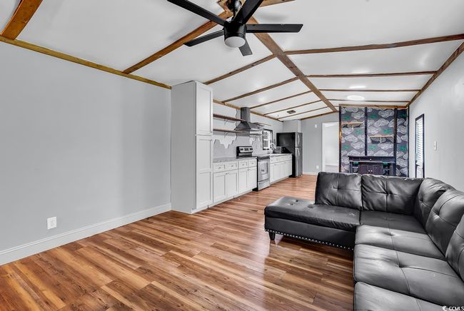 Living area with a ceiling fan, light wood-style floors, and baseboards | Image 20