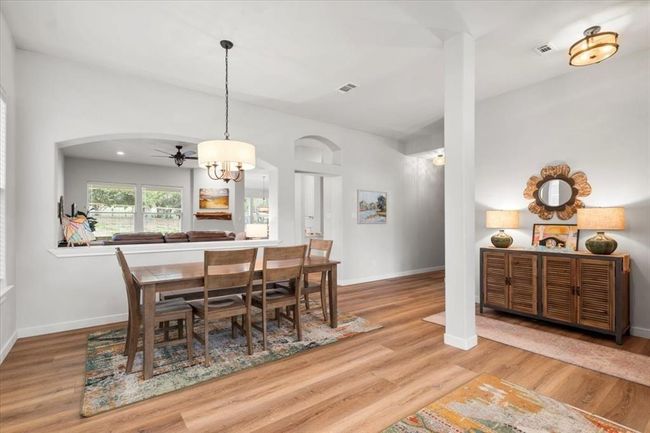 Dining space featuring arched walkways, visible vents, baseboards, and wood finished floors | Image 5
